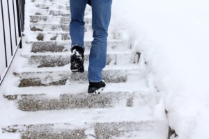 man-slipping-while-climbing-snowy-stairs-in-the-winter